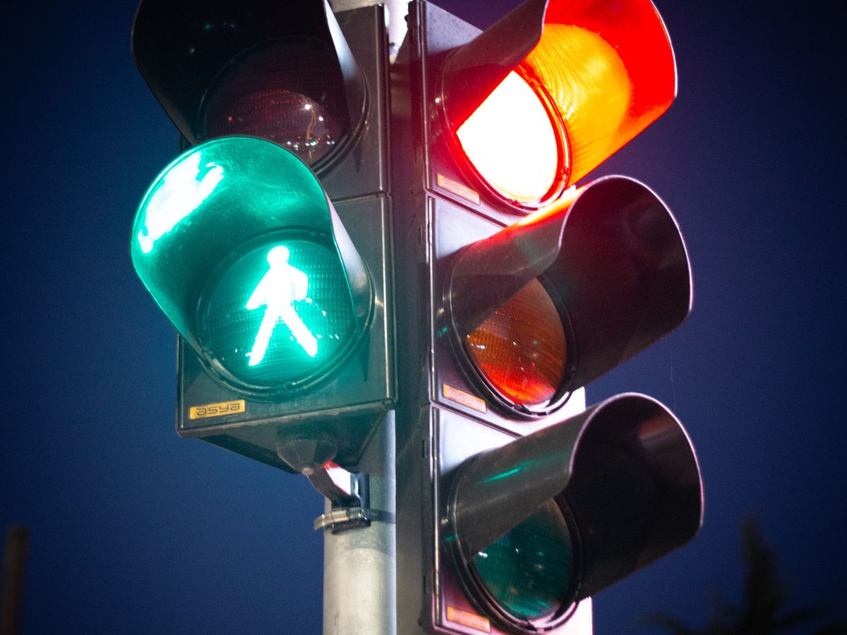 Semáforo em LED em cruzamento urbano ao anoitecer