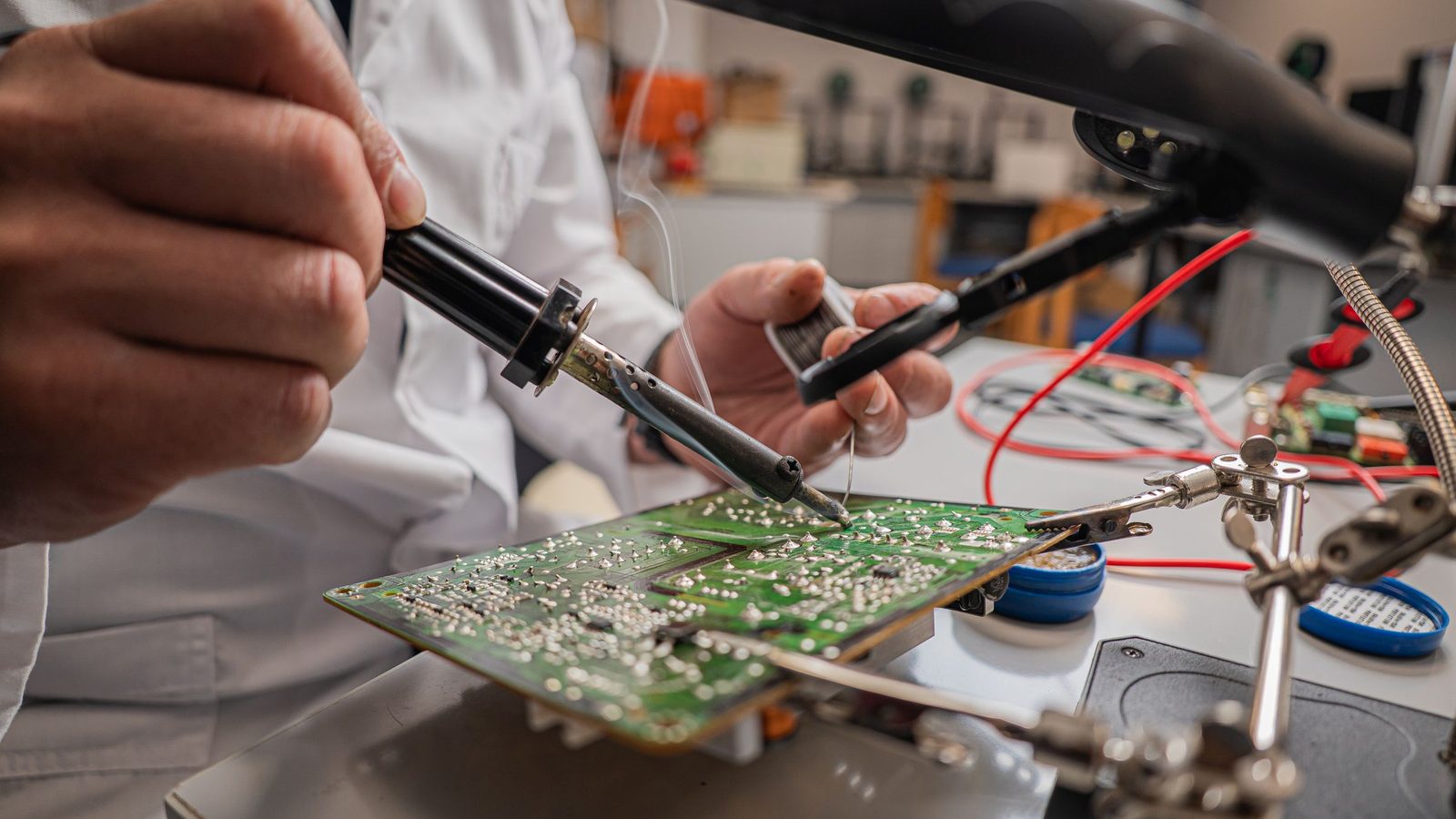 Laboratório de eletrônica com engenheiros de costas montando placas