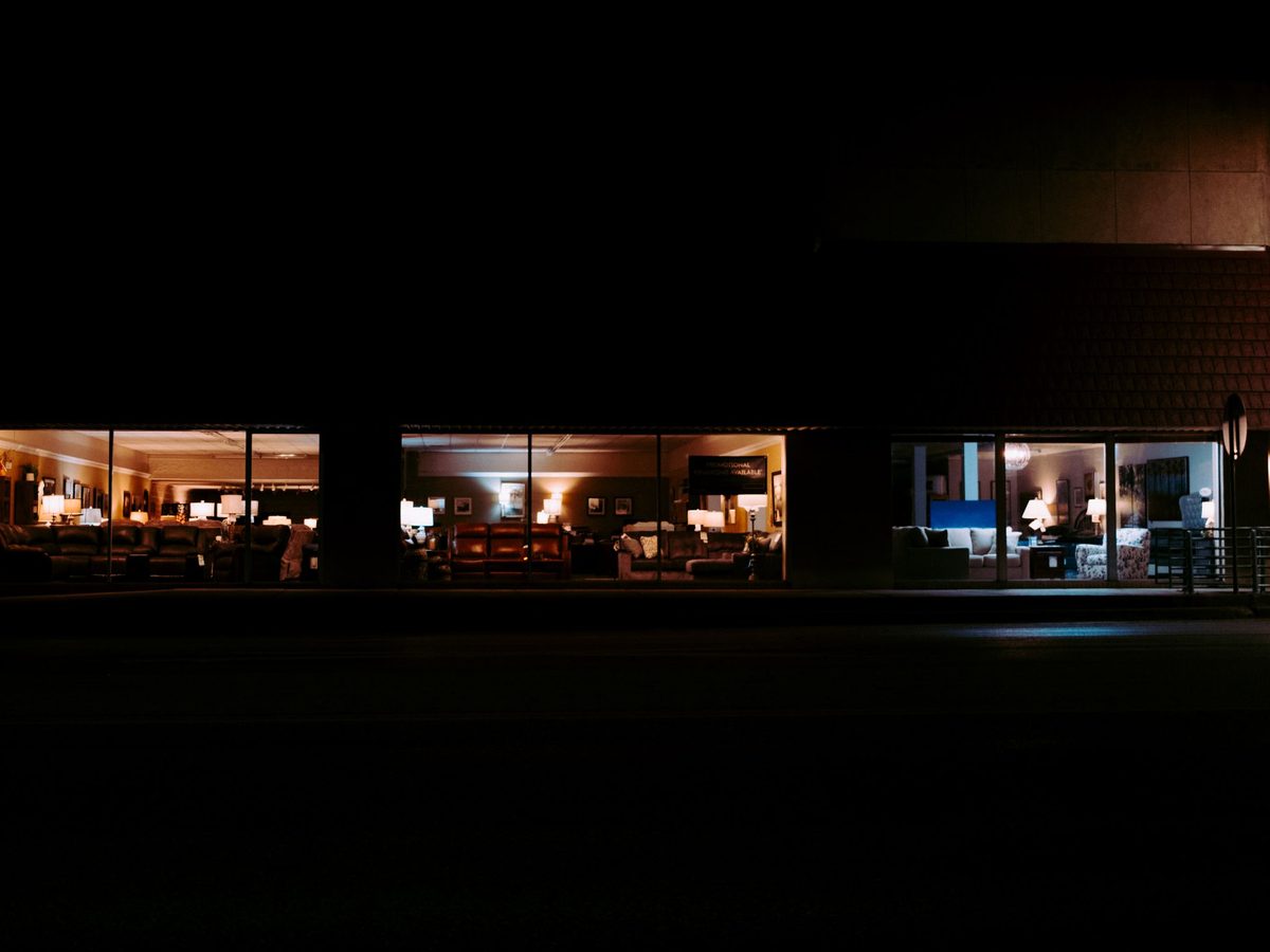 Fachada de loja fechada à noite com câmera e sensor de presença